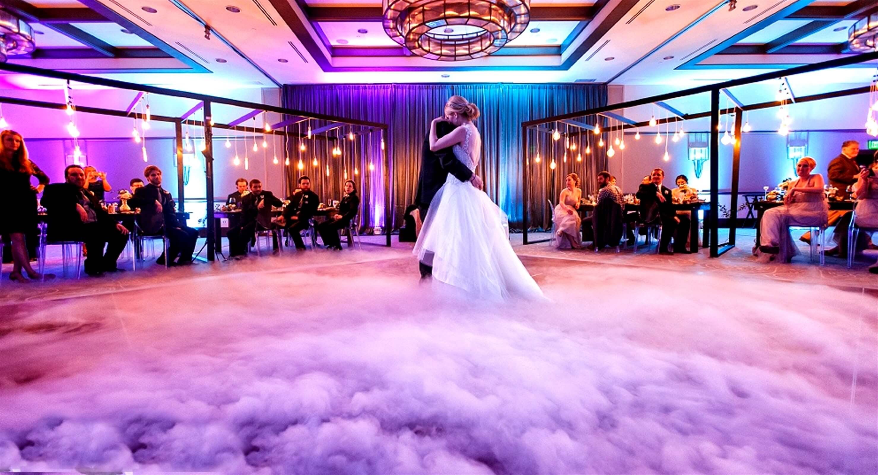 bride and groom dancing through fog